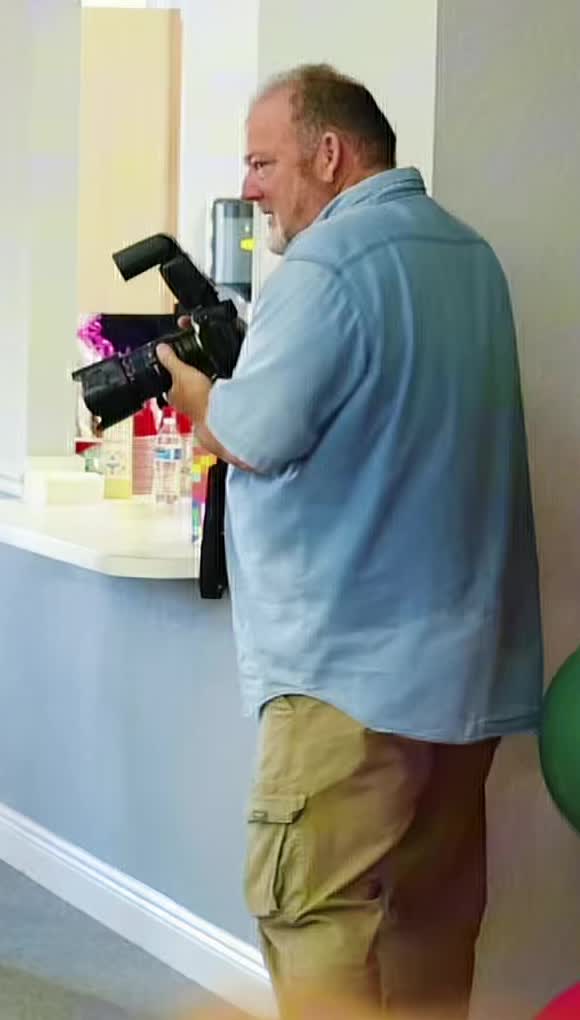 Jim Donnelly holding his camera at the birthday celebration