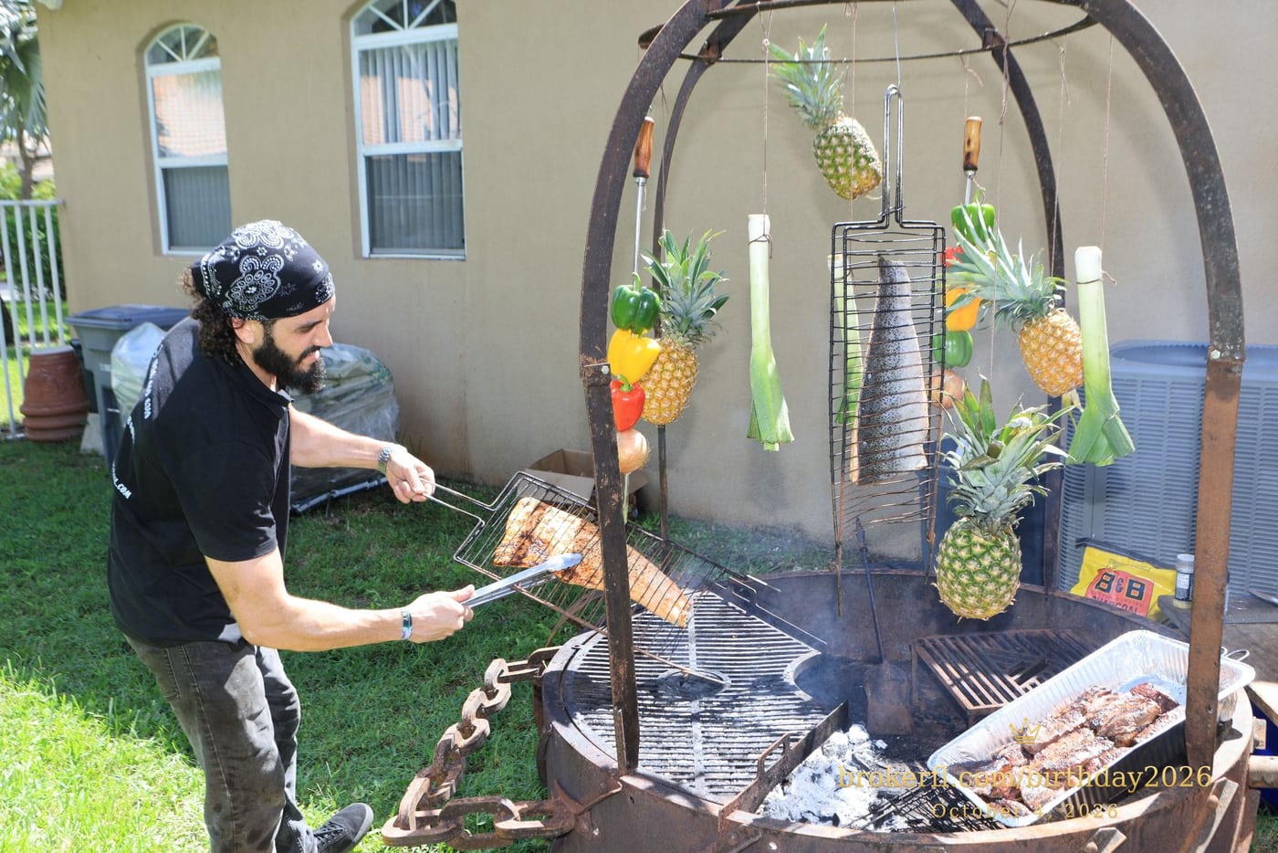 Barbecue cooking over an outdoor fire with hanging vegetables — Karina Leal's birthday, October 4, 2026.