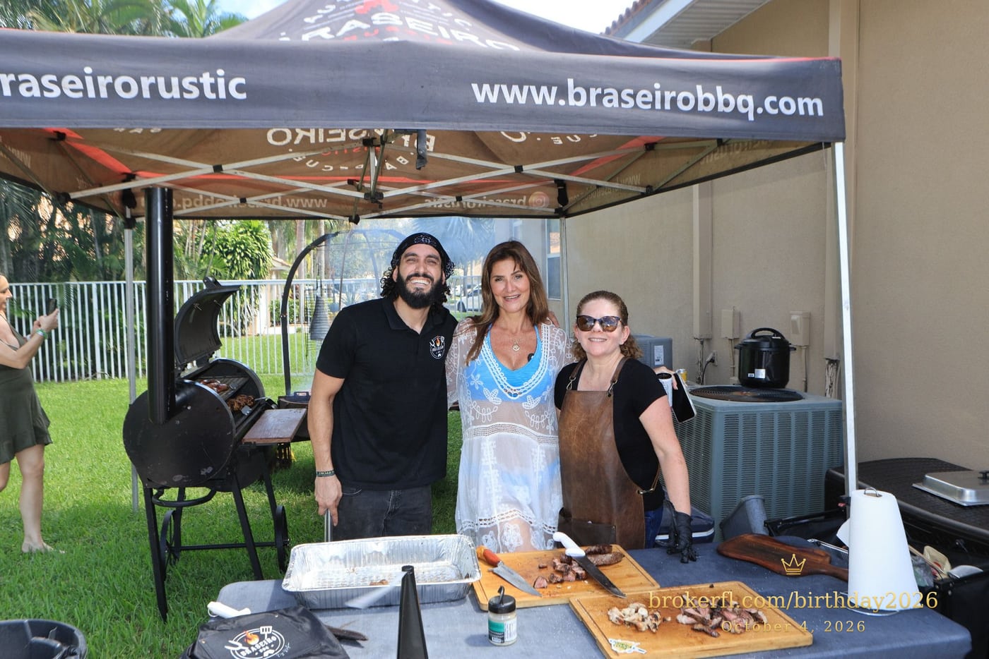 Guests posing with the barbecue team at the outdoor cooking station — Karina Leal's birthday, October 4, 2026.
