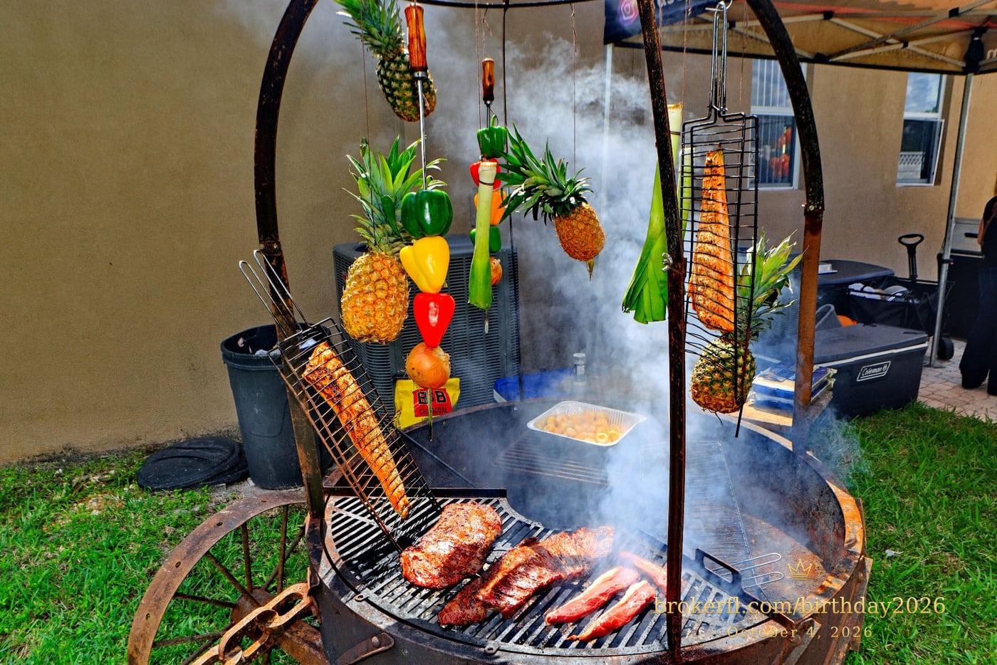 Barbecue cooking over an outdoor fire with hanging vegetables — Karina Leal's birthday, October 4, 2026.