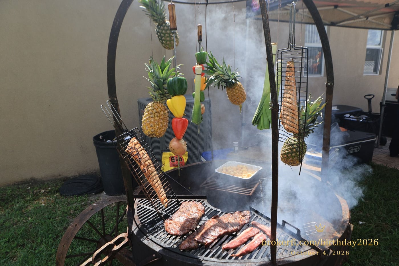 Barbecue cooking over an outdoor fire with hanging vegetables — Karina Leal's birthday, October 4, 2026.