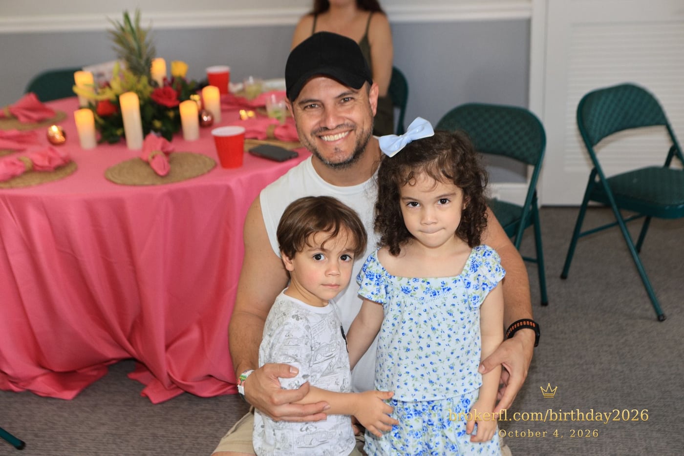Adult holding two children inside the party room — Karina Leal's birthday, October 4, 2026.