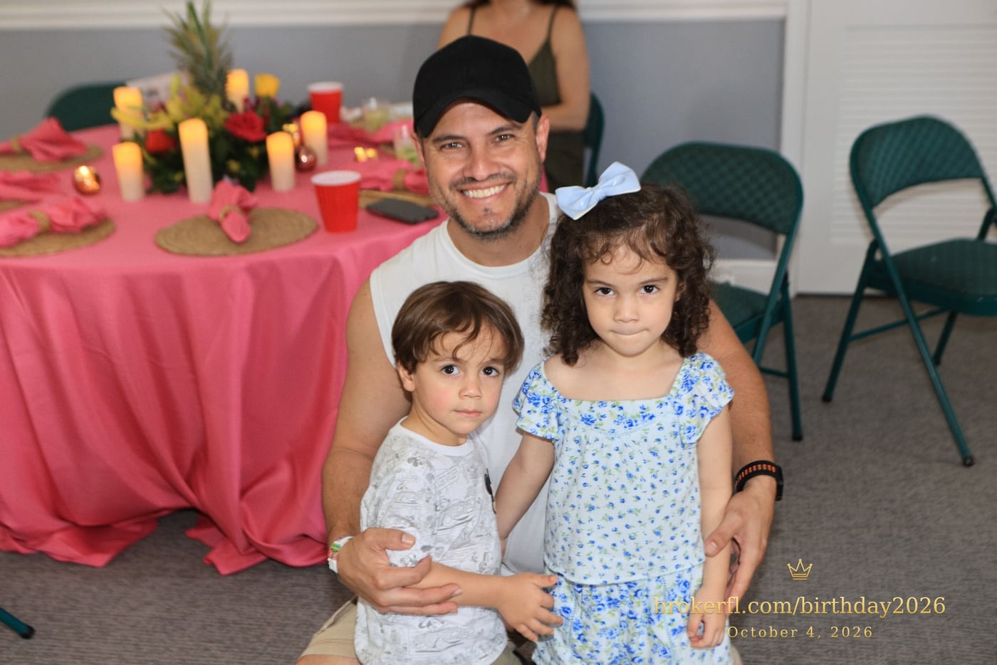Adult holding two children inside the party room — Karina Leal's birthday, October 4, 2026.