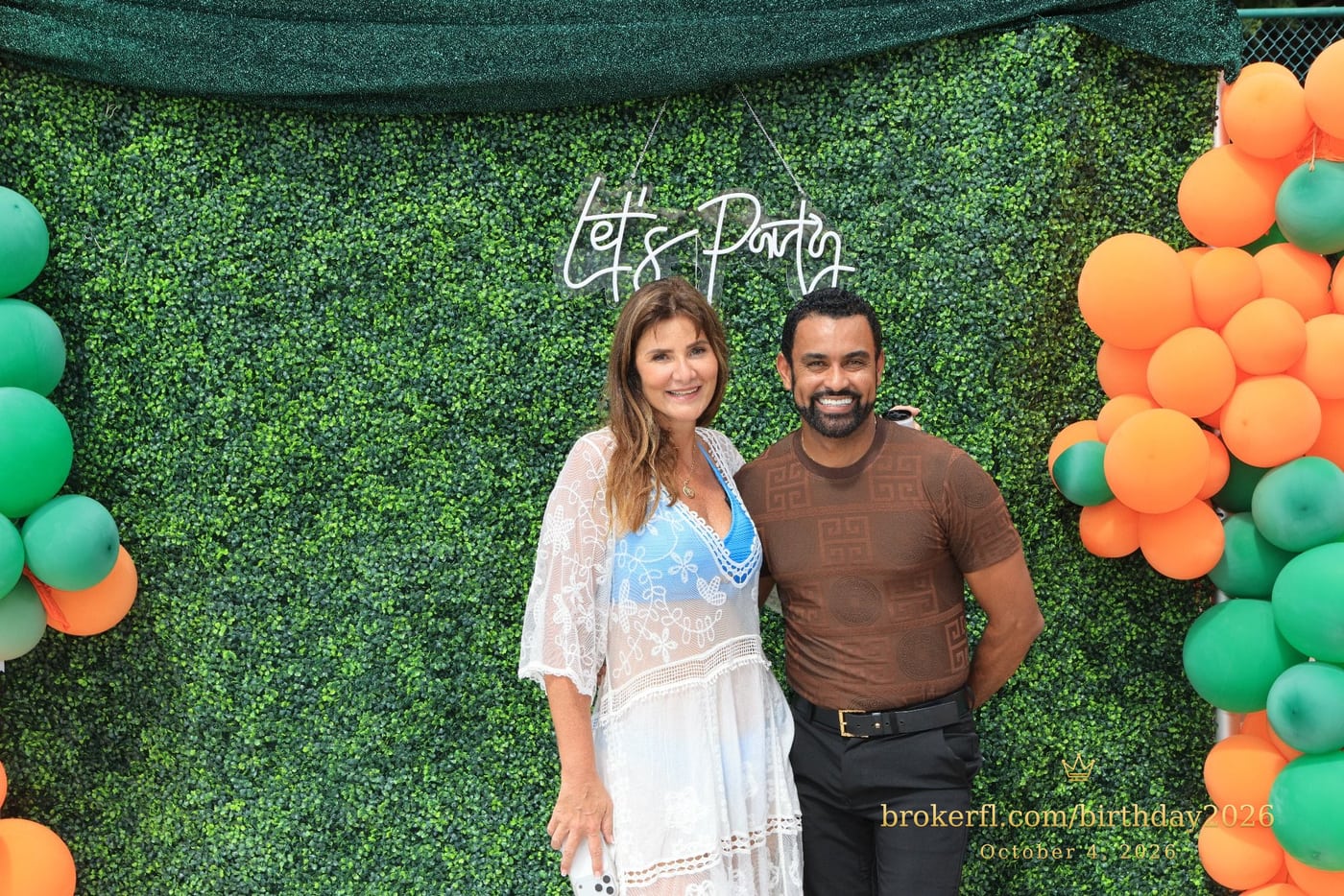 Guests posing in front of the outdoor green and orange balloon backdrop — Karina Leal's birthday, October 4, 2026.