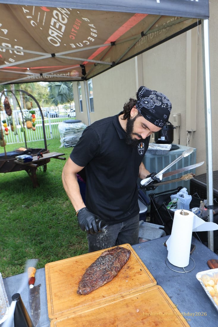 Cook carving barbecue meat at the outdoor station — Karina Leal's birthday, October 4, 2026.