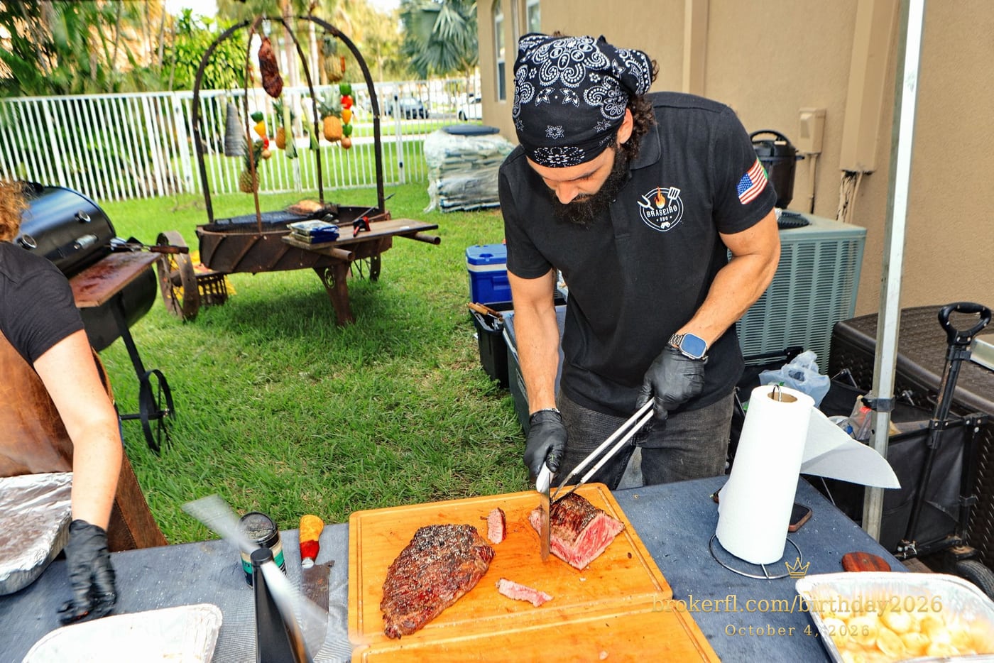 Cook carving barbecue meat at the outdoor station — Karina Leal's birthday, October 4, 2026.