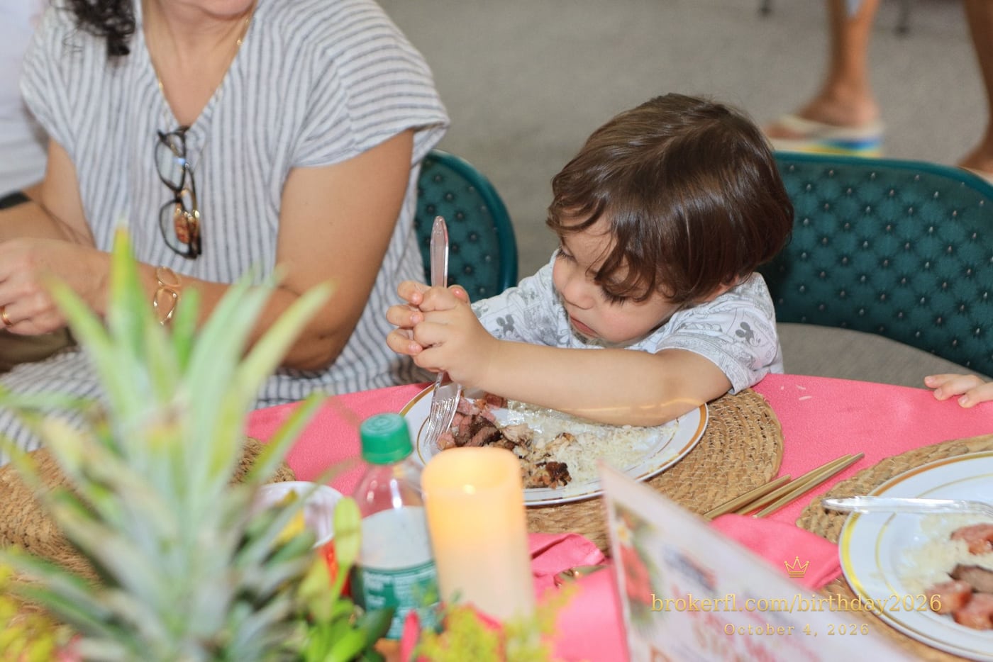 Child seated beside an adult at a pink party table — Karina Leal's birthday, October 4, 2026.