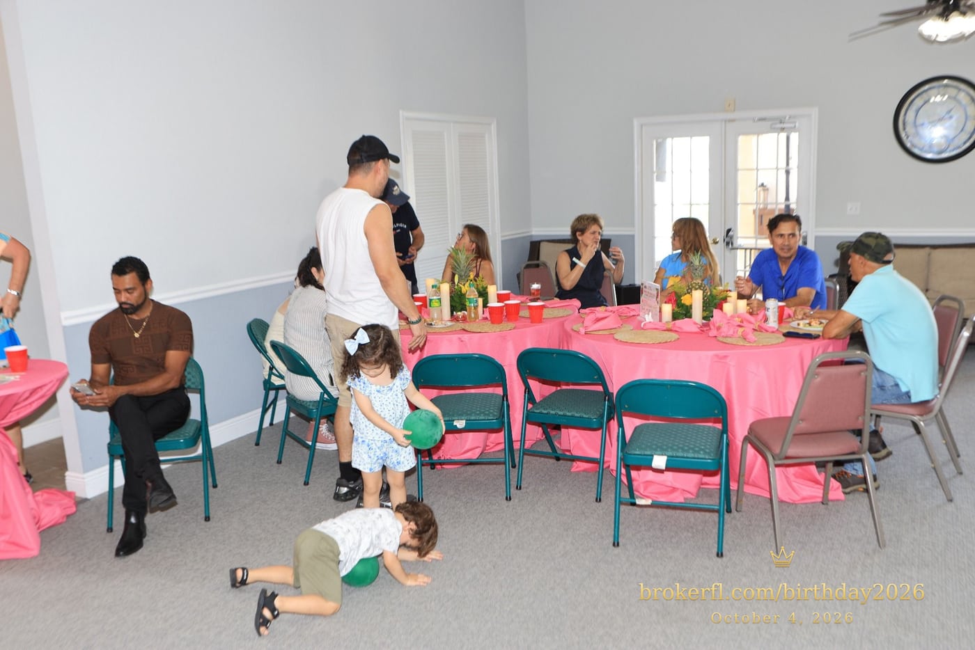Guests gathered around pink dining tables in the party room — Karina Leal's birthday, October 4, 2026.
