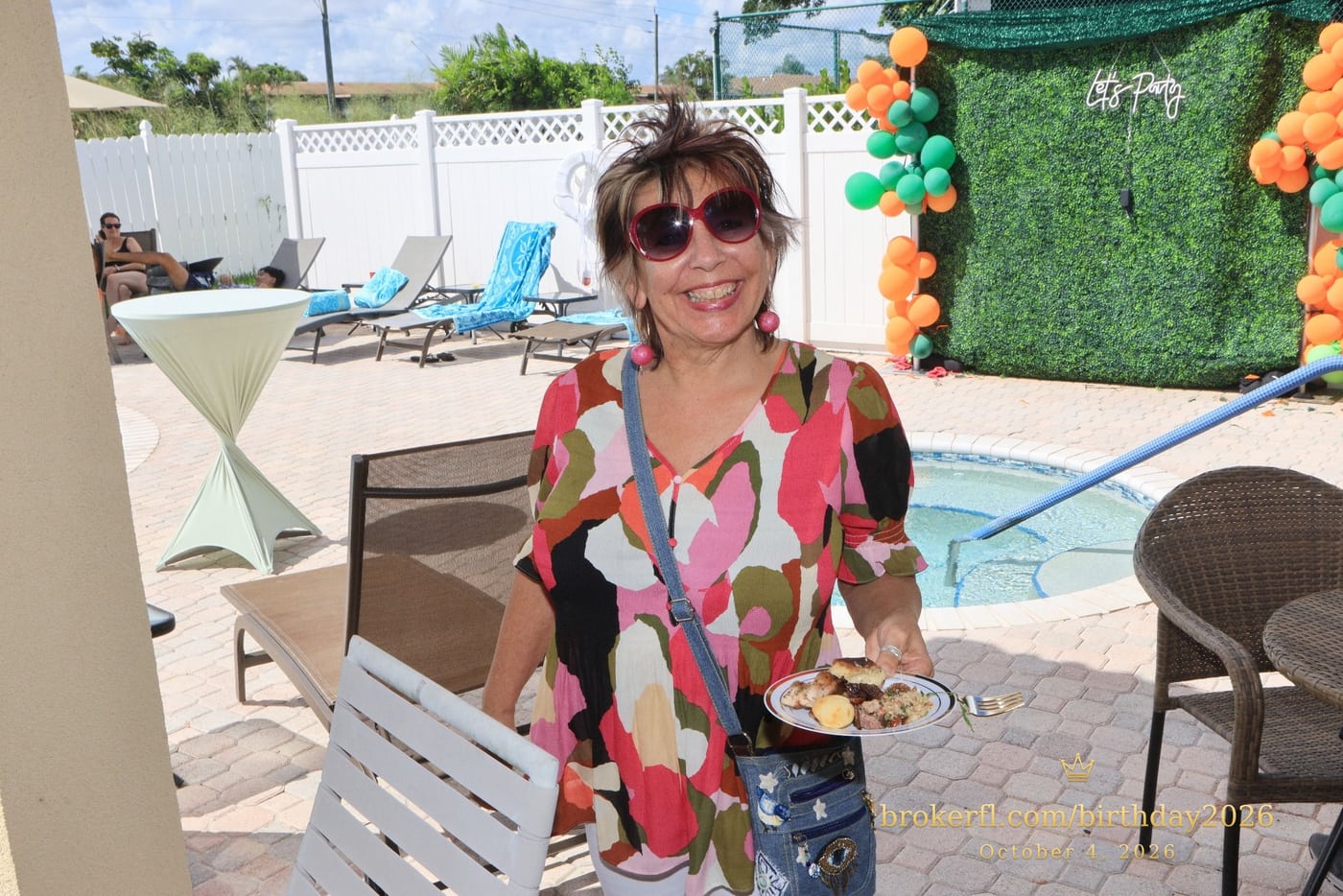Guest in a colorful blouse standing on the poolside patio — Karina Leal's birthday, October 4, 2026.