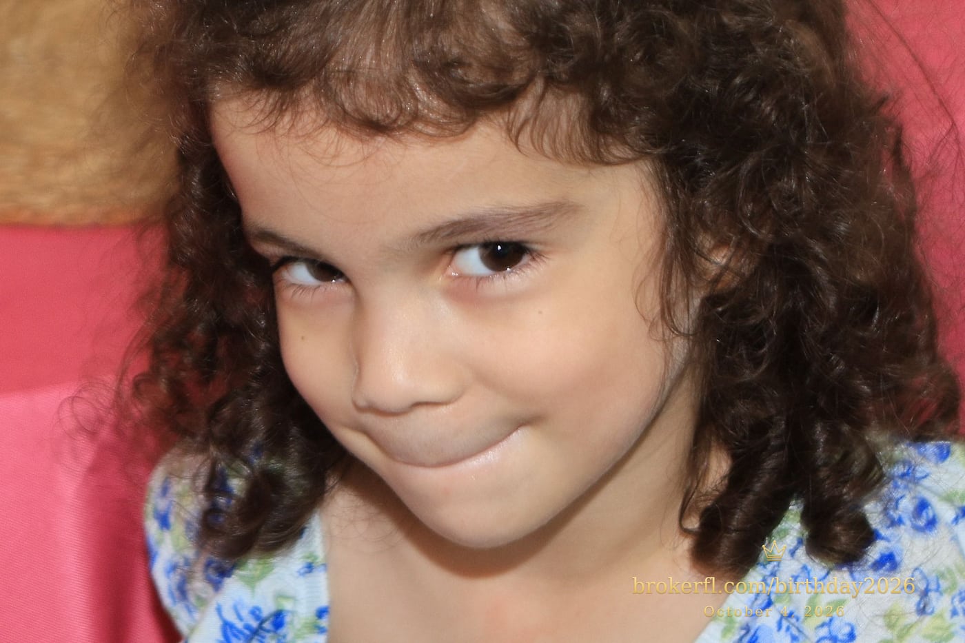 Young guest in a blue dress smiling inside the party room — Karina Leal's birthday, October 4, 2026.