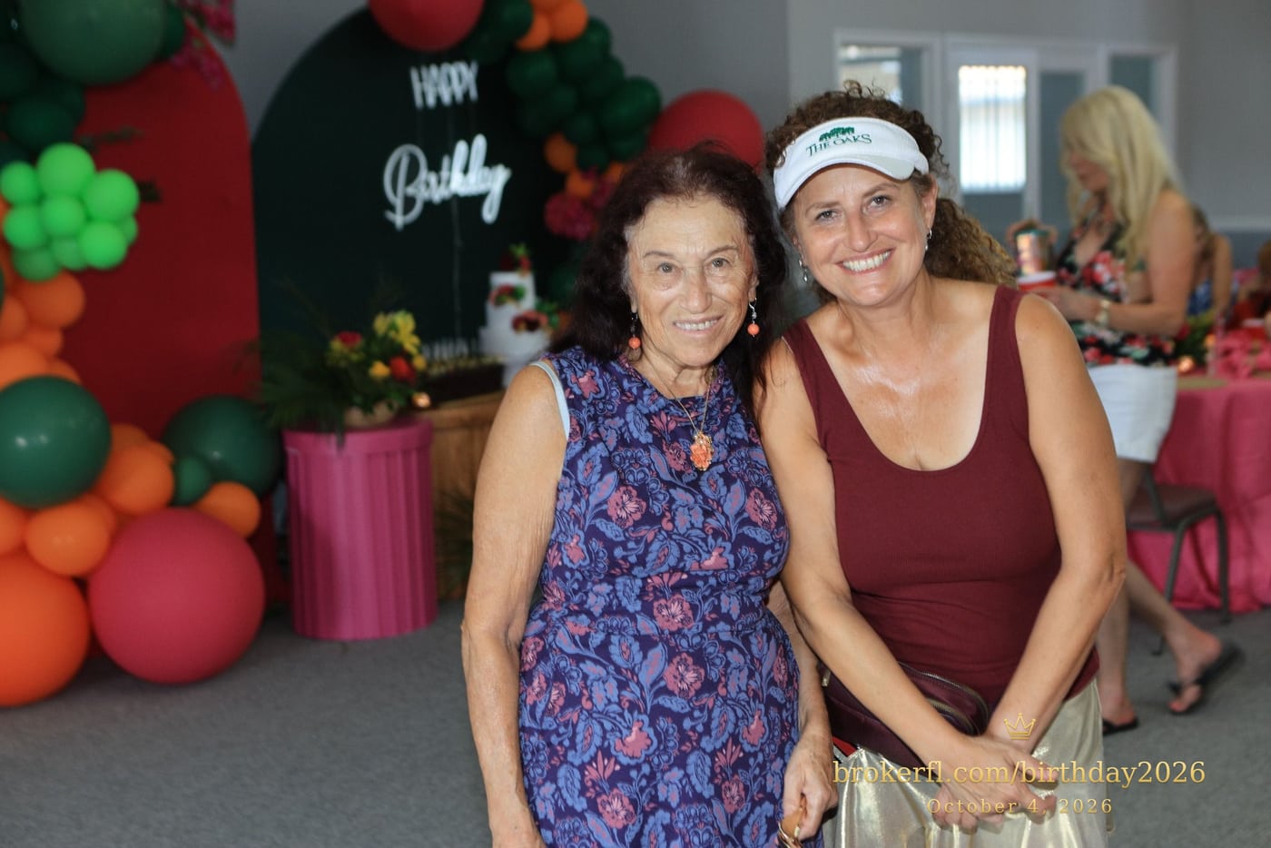 Two guests posing together in front of the balloon decorations — Karina Leal's birthday, October 4, 2026.