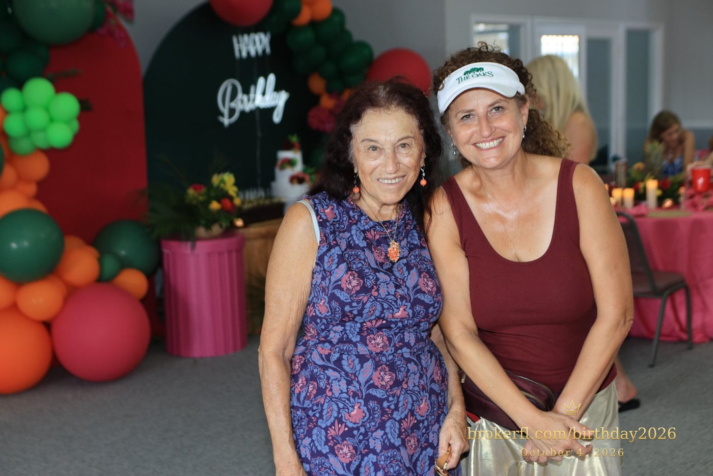 Two guests posing together in front of the balloon decorations — Karina Leal's birthday, October 4, 2026.