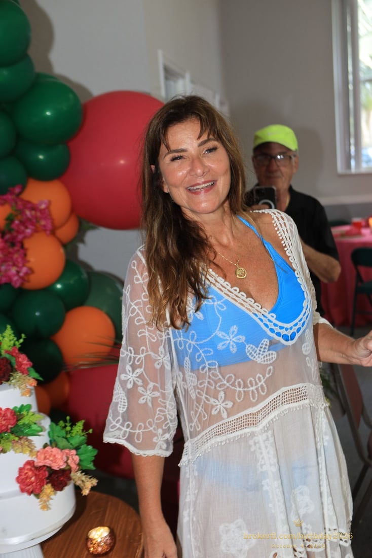 Birthday portrait beside tropical flowers and colorful balloons — Karina Leal's birthday, October 4, 2026.