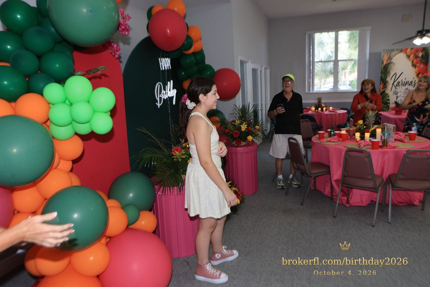 Guest in a cream dress beside the birthday cake display — Karina Leal's birthday, October 4, 2026.