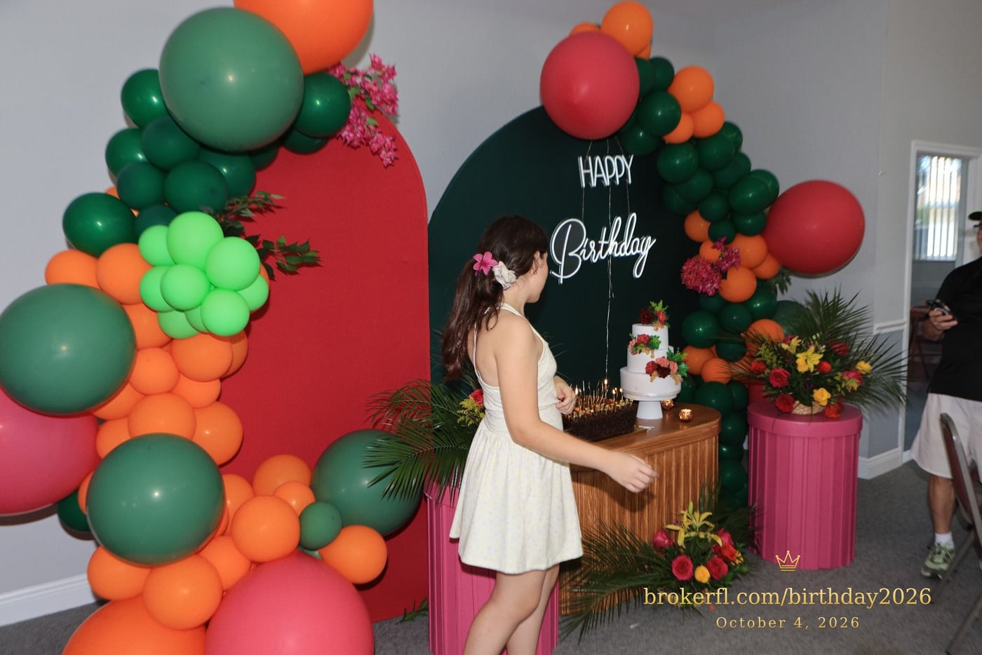 Guest in a cream dress beside the birthday cake display — Karina Leal's birthday, October 4, 2026.
