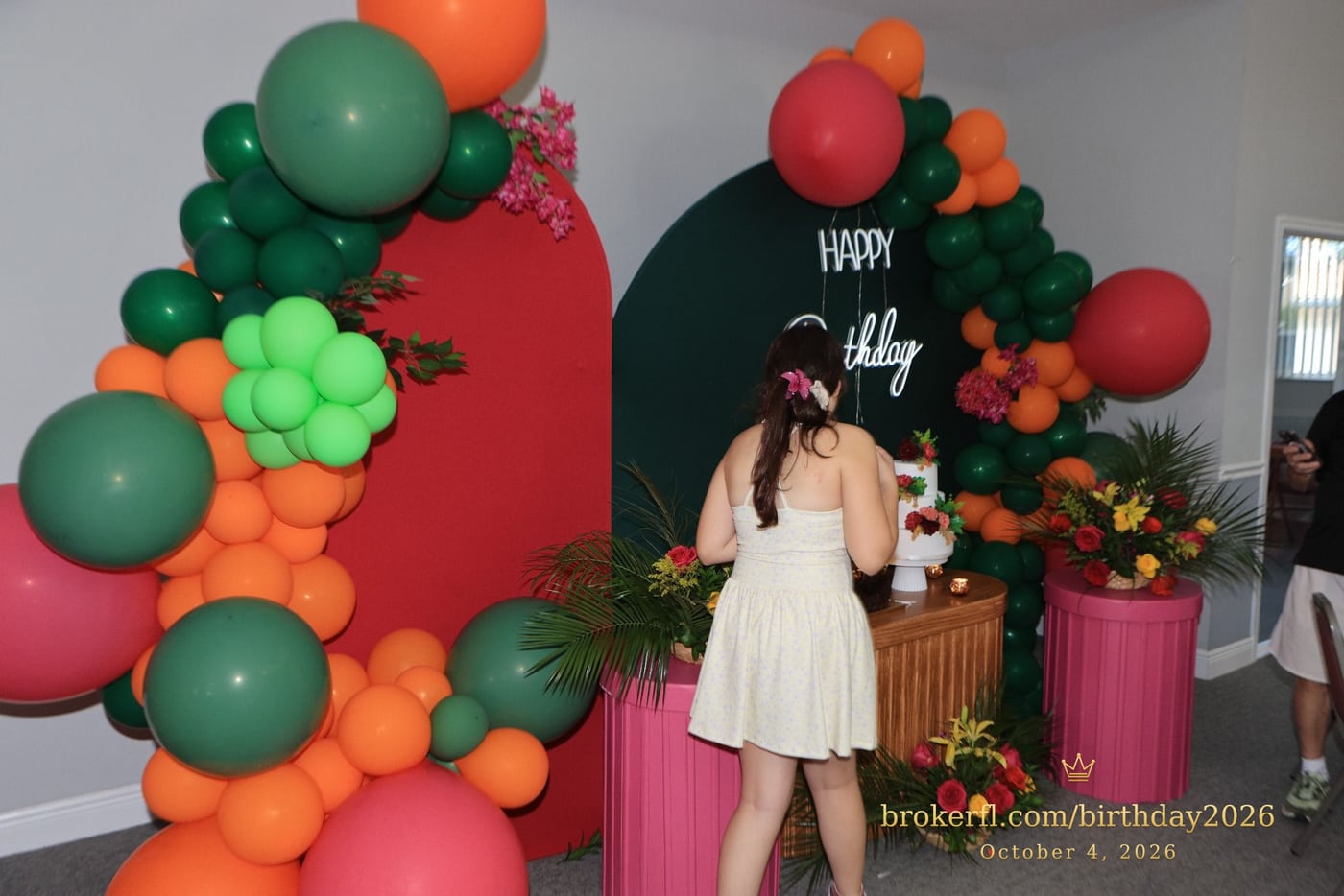 Guest in a cream dress beside the birthday cake display — Karina Leal's birthday, October 4, 2026.