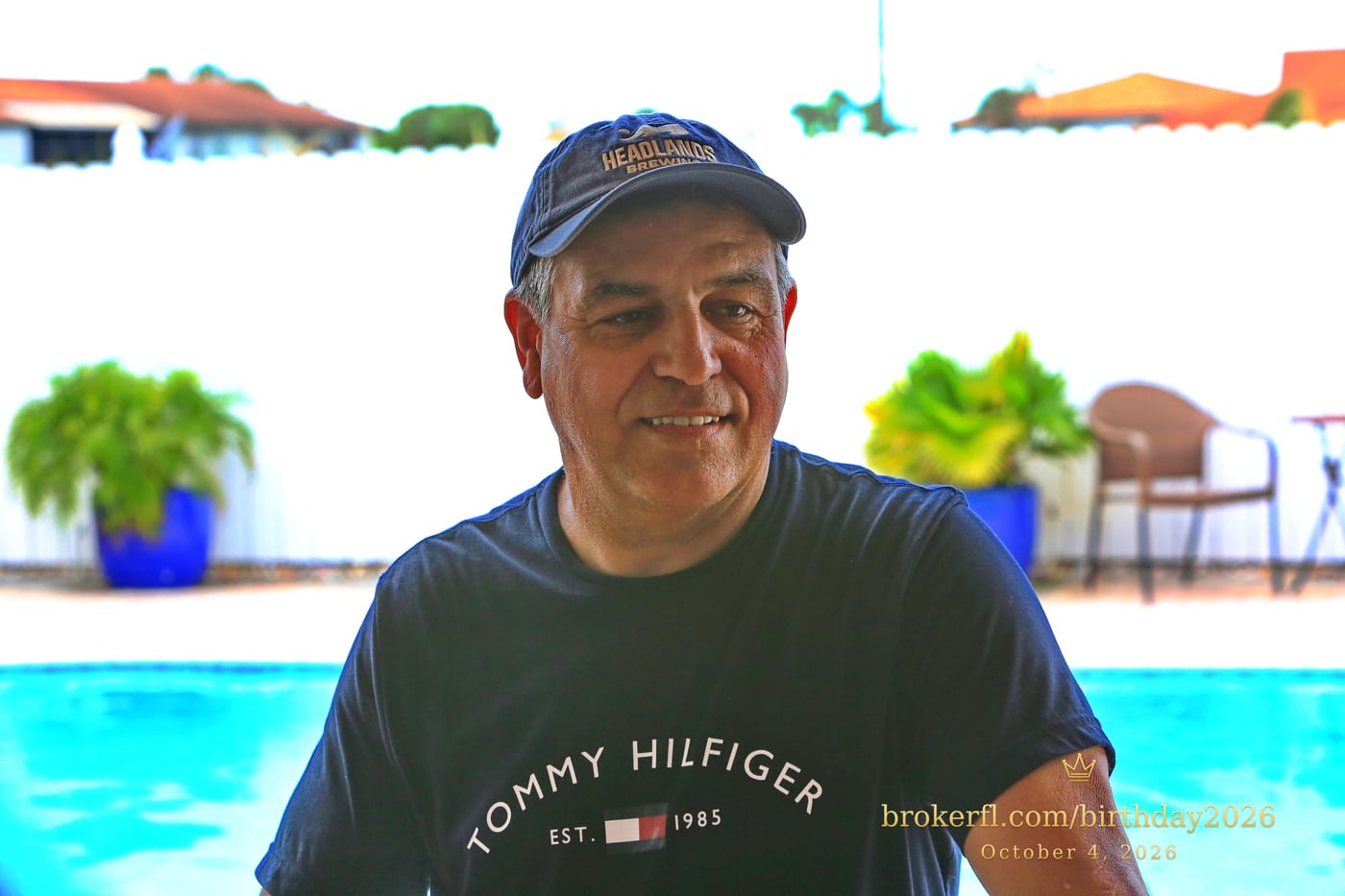 Guest in a dark shirt smiling on the poolside patio — Karina Leal's birthday, October 4, 2026.